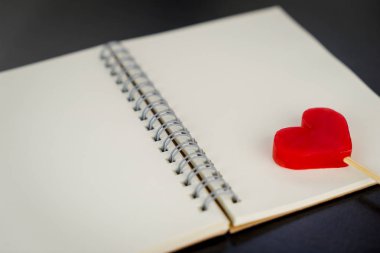 Boş günlük defter sayfası üzerinde kırmızı kalp şeker