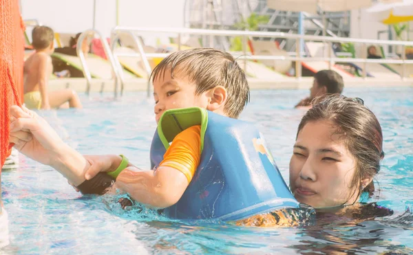 Asiático chico está tomando natación clase con instructor — Foto de Stock