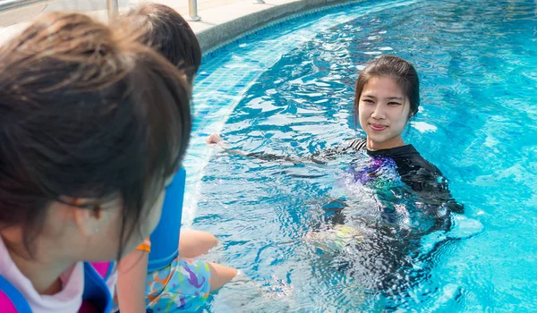 Instructor de natación está enseñando a los niños a nadar —  Fotos de Stock