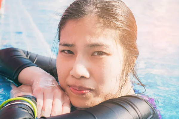 Menina asiática em maiô completo descansando na beira da piscina — Fotografia de Stock