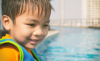 Islak Asya oğlan havuz üzerinde oturuyor