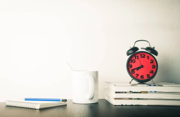 Relógio despertador com café da manhã e livro em branco na mesa de escritório — Fotografia de Stock