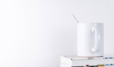 Kitap ile beyaz arka plan üzerinde beyaz kahve kupa