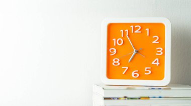 Turuncu saat ile beyaz kopyalama boşluk duvar üstüne yığılmış