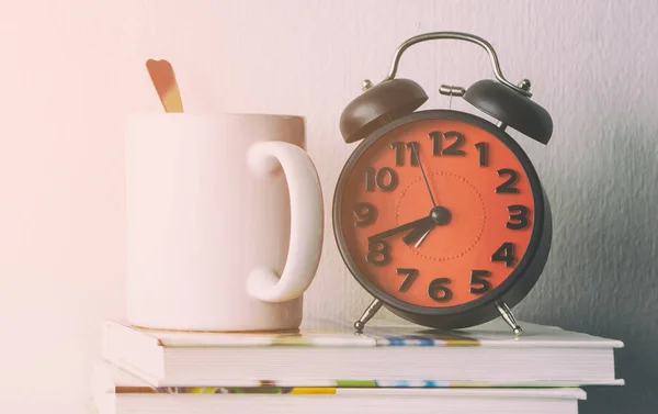 Relógio despertador com café da manhã na mesa do escritório — Fotografia de Stock