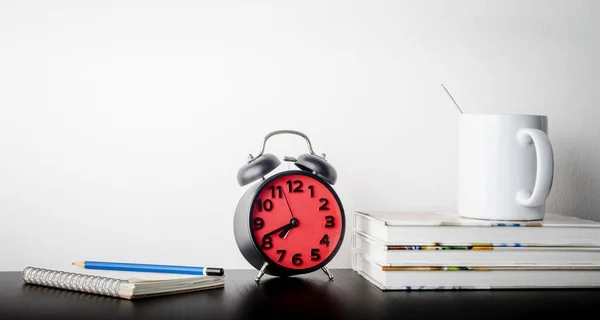Reloj despertador con café de la mañana y libro en blanco en la mesa de oficina — Foto de Stock