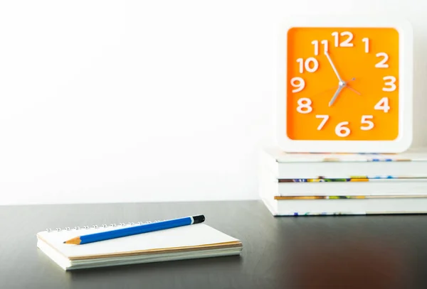 Orange clock on stacked book with white copy space wall for writter — Stock Photo, Image