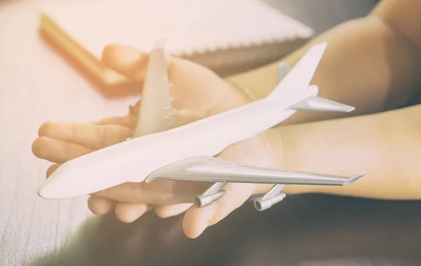 Child hands sostiene un juguete de avión blanco para el concepto de viaje de Chidlren — Foto de Stock