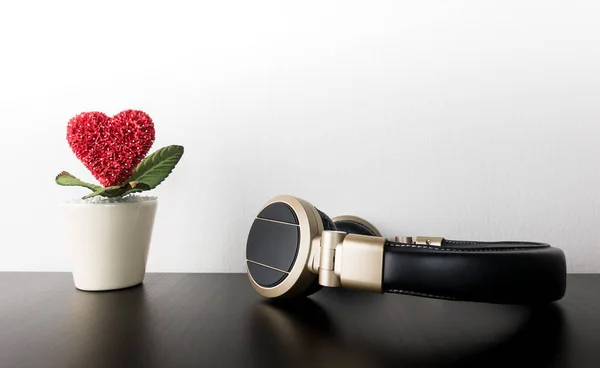 Amor jarra de flores corazón rojo con auriculares para la música del amor — Foto de Stock