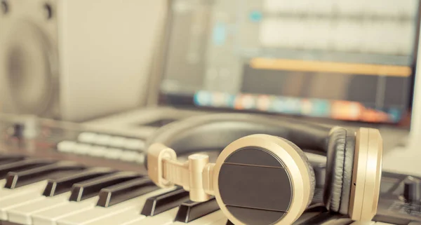 作業用デスクトップ上に横たわる黄金の音楽スタジオ ヘッドフォン — ストック写真