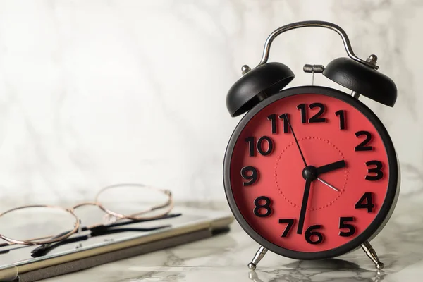 Alarme rouge Clcok compte jusqu'à la date limite sur table en marbre luxueux avec tablette et lunettes — Photo