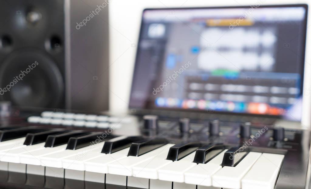 Synthesizer keyboard lying on Music studio working desktop
