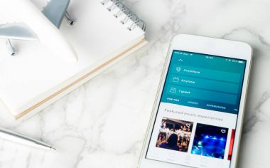 Bangkok, Tayland - 9 Şubat 2017: Bir işadamı kitap onun seyahat smartphone için Airbnb kullanma.