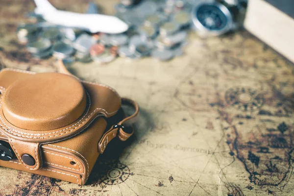 Leather camera case and traveler equipment on vintage map