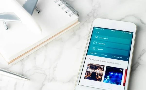 Bangkok, Tayland - 9 Şubat 2017: Bir işadamı kitap onun seyahat smartphone için Airbnb kullanma.