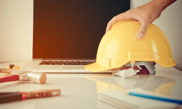 Інженерний працівник, будівельник, ремонтник чоловік збирає шолом безпеки з офісного столу — стокове фото