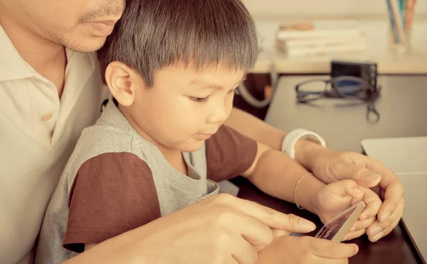 Padre está enseñando a su hijo a usar la tecnología de teléfonos inteligentes sabiamente — Foto de Stock