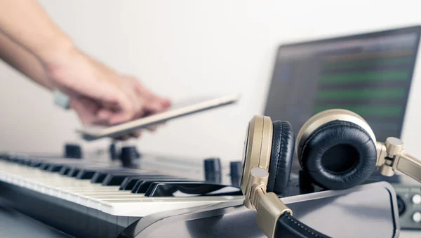 Músico usando mesa para controlar o aplicativo de desktop de trabalho de estúdio de música — Fotografia de Stock