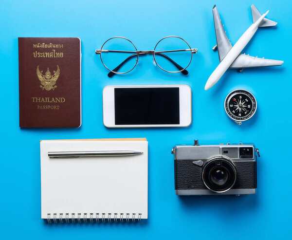 Travel accessories with blank mobile screen on blue background