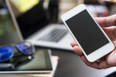 İş adamı boş hpone ekran ofisinde tutuyor