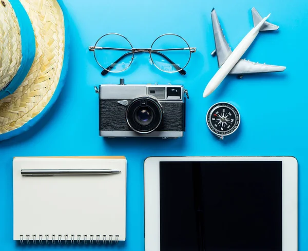 Travel blogger accessories on blue copy space for travel poster.