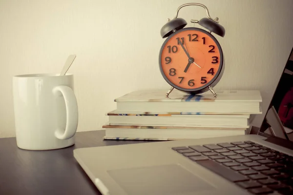 Réveil du matin et café sur la table de bureau avec ordinateur — Photo