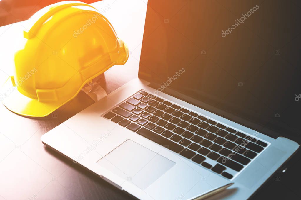 Engineer working table with computer and safety helmet