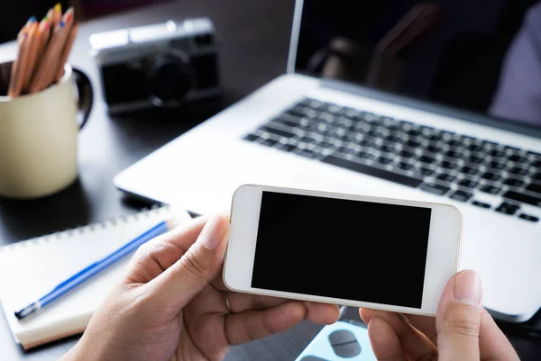 Oficina creativa está sosteniendo una pantalla de teléfono inteligente en blanco para maqueta — Foto de Stock