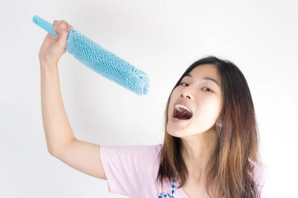 Feliz ama de casa sosteniendo removedor de polvo como micrófono cantando — Foto de Stock