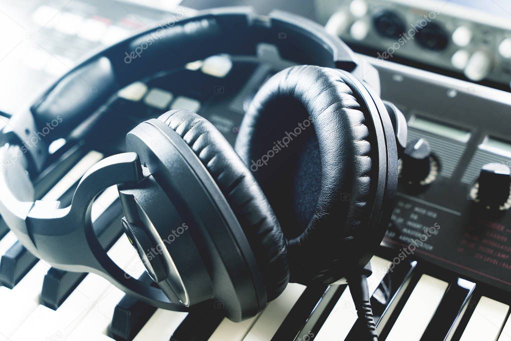 Studio headphone lying on keyboard synthesizer studio