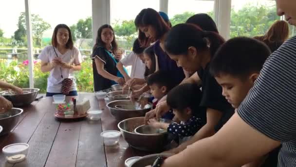 Gezin met kleine kinderen koken in een bakkerij kookles. — Stockvideo