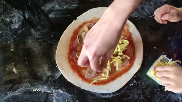 Дети делают домашнюю пиццу приготовления стола вид сверху — стоковое видео