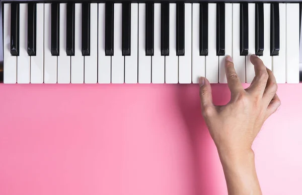 La mano del tastierista sta giocando sulla tastiera con spazio di copia rosa — Foto Stock