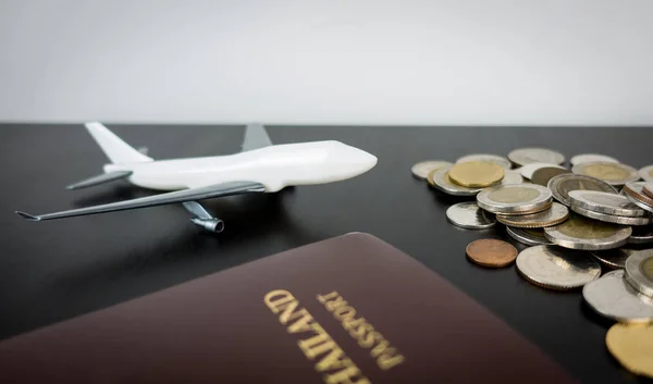 Ahorro de dinero para viajar con avión, pasaporte y moneda en la mesa — Foto de Stock