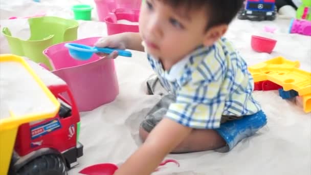Японський хлопчик грає в барвисті пісочниці майданчик. — стокове відео