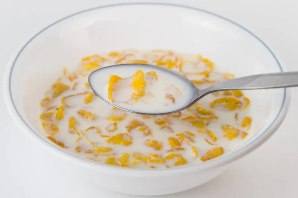 Jednoduché sladké obilovin s mlékem v míse lžičkou — Stock fotografie