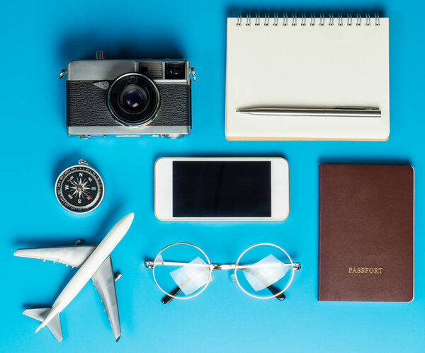 Traveler tools and documents flatlay on blue surface