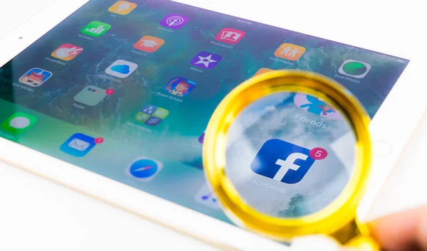 Büyüteç camı üzerinde iPad Facebook uygulaması üzerinden seyir.