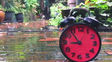 Zaman atlamalı bir kırmızı alarm saatinin yağmurlu günde hızlandırmak