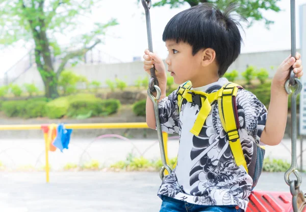 Ásia menino jogar no o playground swing com cópia espaço — Fotografia de Stock