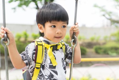 Asyalı Çocuk Bahçesi bir salıncak üzerinde oynuyor