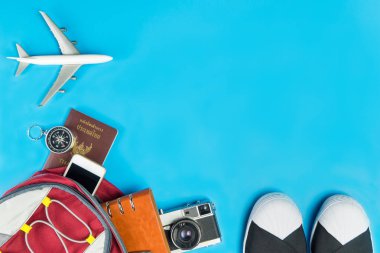 Backpacker seyahat aksesuarları ile mavi arka plan üzerinde oyuncak uçak