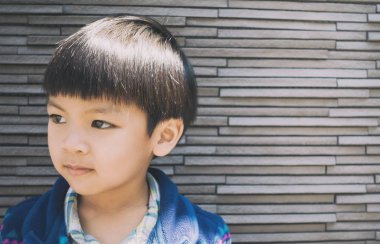 Asyalı çocuk potrait kayanın üzerine duvar arka plan karoları