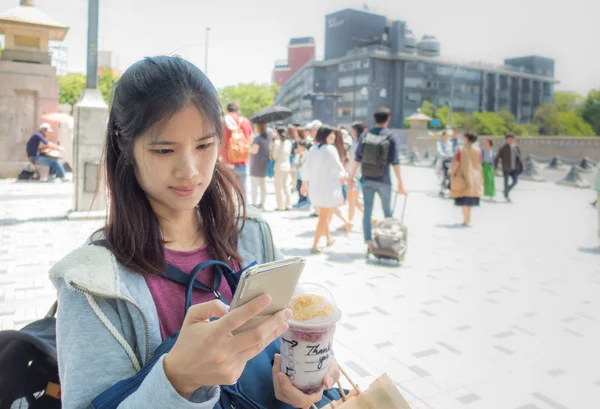 Femme voyageuse utilise le téléphone dans la rue Harajuku — Photo