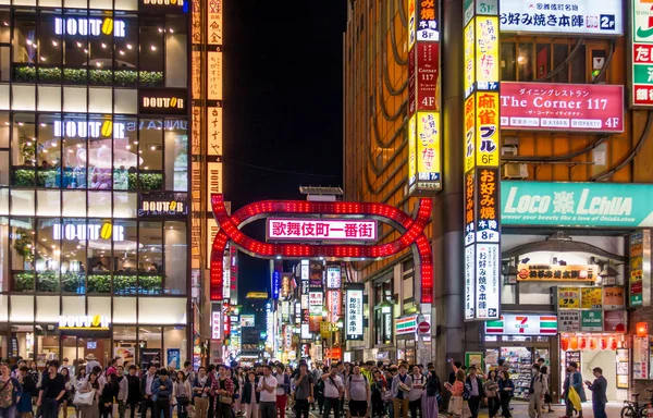 Les gens traversent la rue dans le quartier commerçant de Shinjuku . — Photo