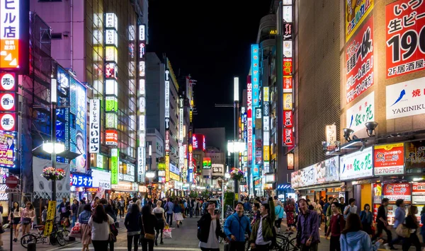 Lidé se scházejí v nákupní čtvrti Shinjuku v noci. — Stock fotografie