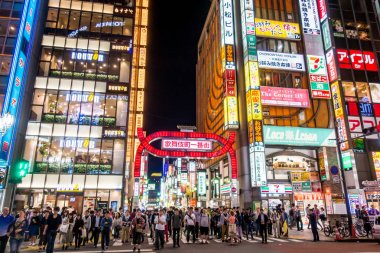 İnsanlar alışveriş caddesi Shinjuku geçiyorlar.