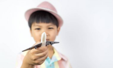 Asyalı çocuk oyuncak uçağa beyaz kopya alanı ile düzenliyor