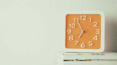 Kitap kopya alanı ile turuncu duvar saati