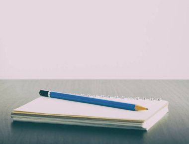 Defter ve kalem en iyi kopya alanı ile siyah bir tabloda